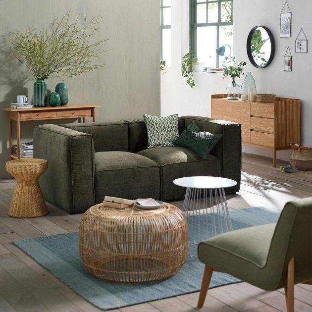 Un canapé en tissu texturé vert kaki foncé et une déco bois Un canapé en tissu texturé vert kaki foncé et une déco bois